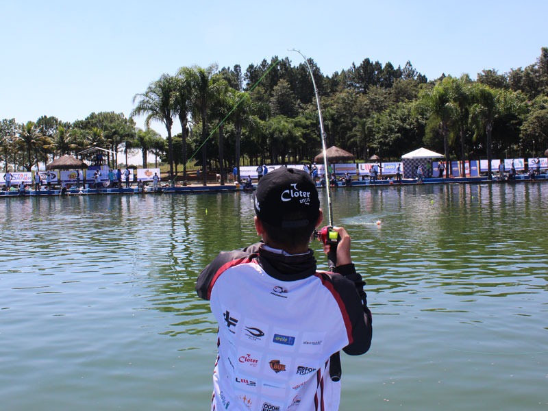Competidor do Campeonato Brasileiro em Pesqueiros, de costas, fisgando um peixe